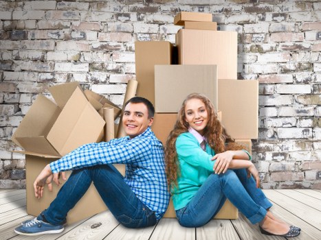 Removalists carrying boxes and furniture in a Kidbrooke flat move